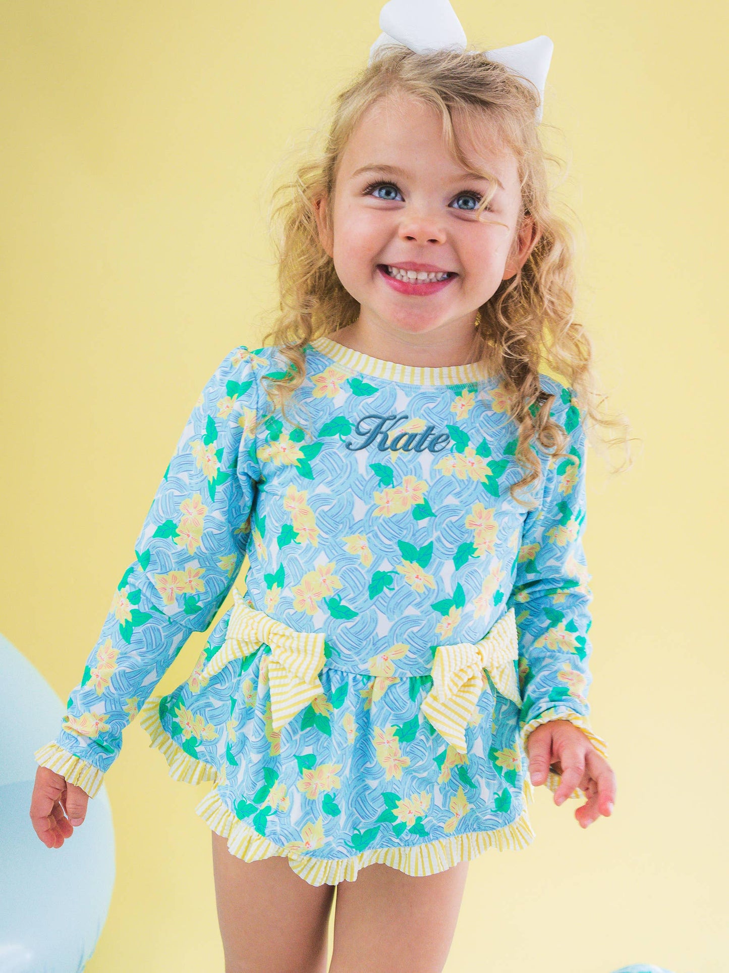 RuffleButts + RuggedButts -  Blooming Basket LS OP Bow Peplum RG Swimsuit